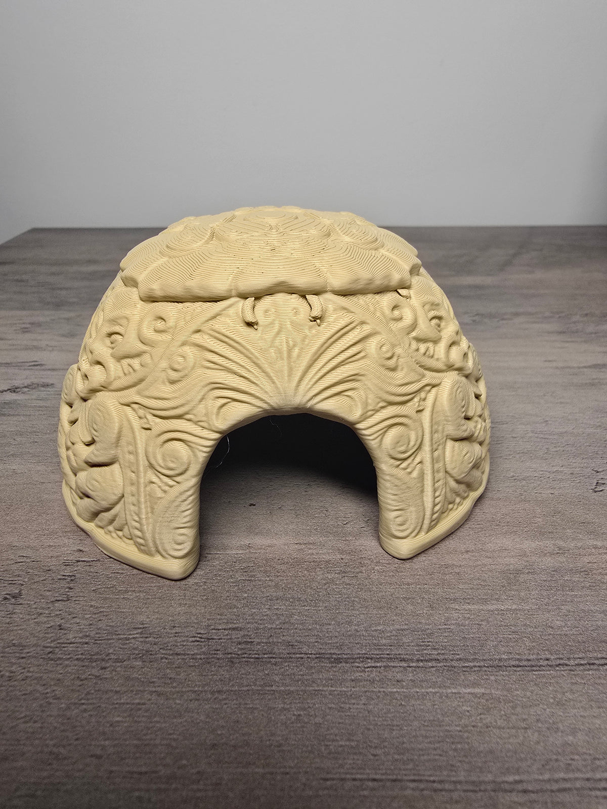 Ornate aquarium cave hideout with raised decorative patterns and an arched entrance