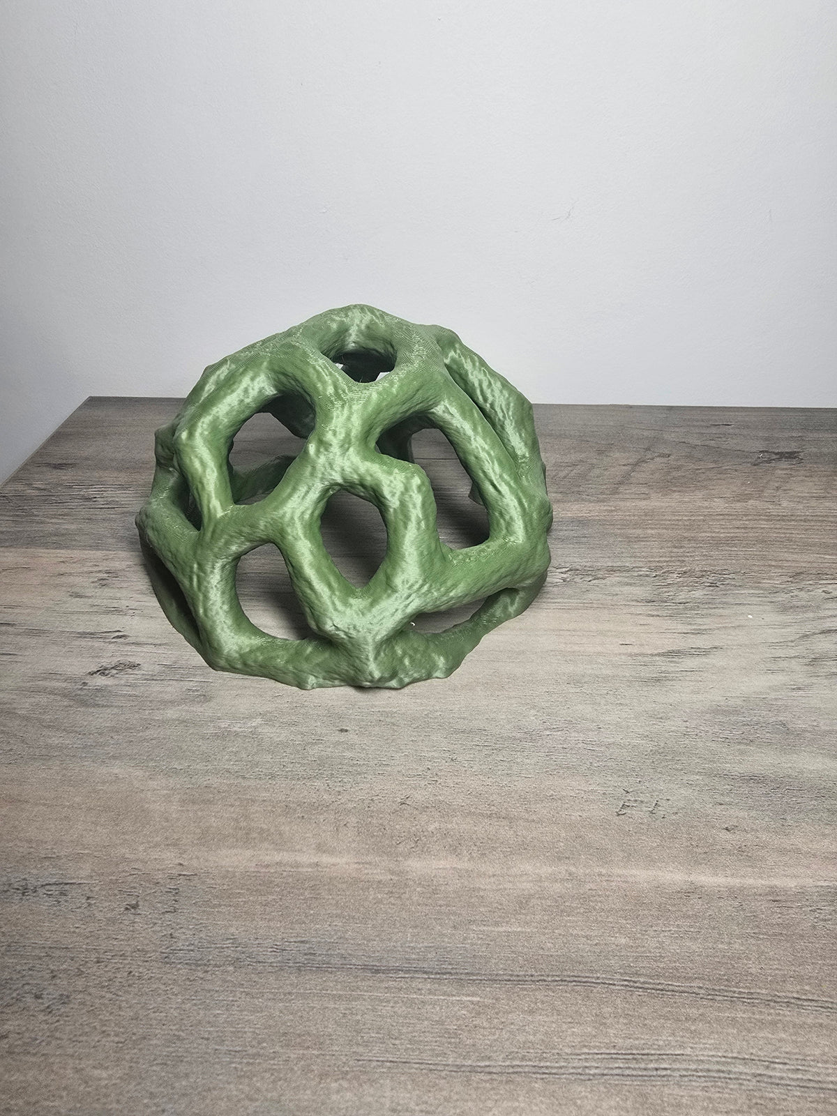 Green rock-style dome aquarium swim-through with multiple irregular openings and a textured surface