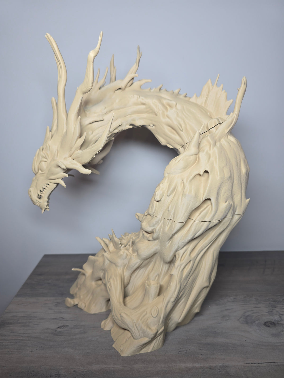 Single-color dragon aquarium sculpture with long horns, a curved neck, textured ridges, and an open arched silhouette